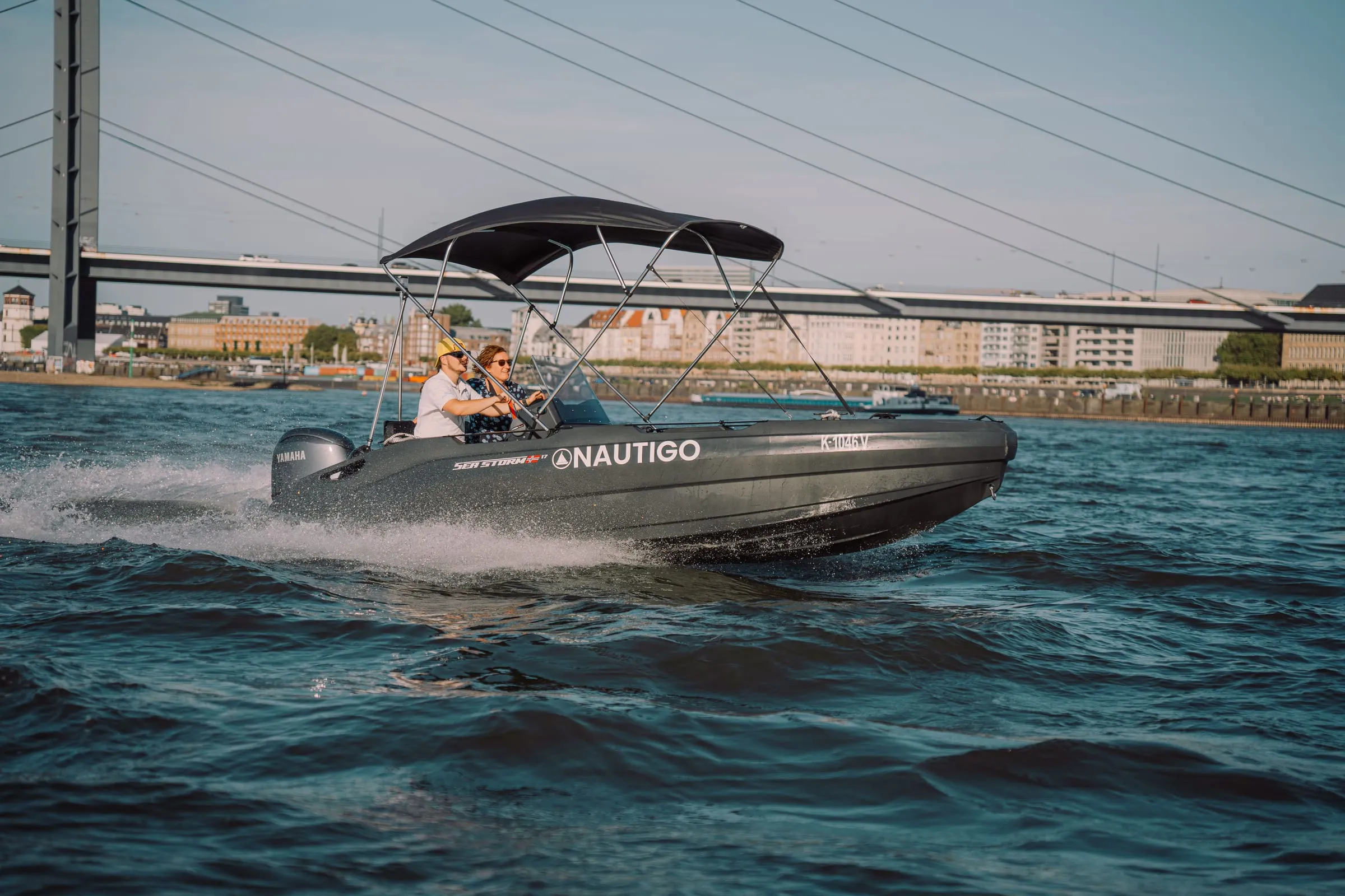 Sports boat with HDPE hull underway on water, wake visible at stern