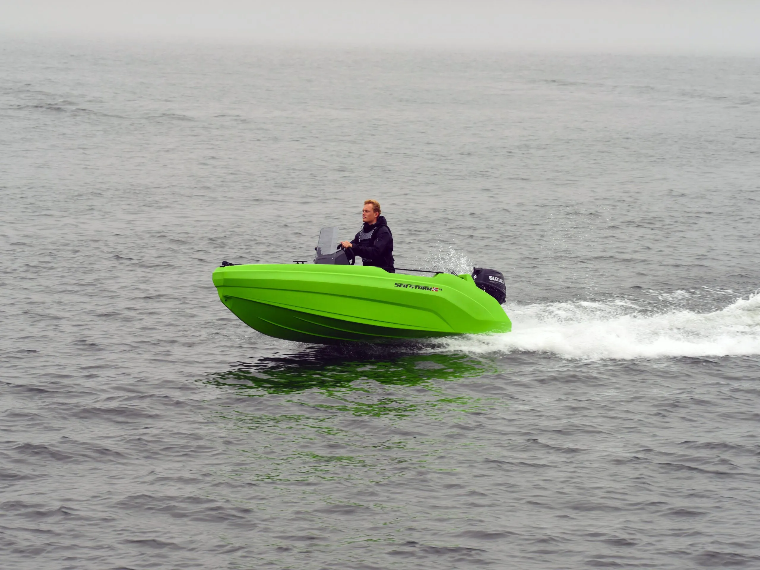 Compact SeaStorm 12 HDPE motorboat with an outboard at a jetty