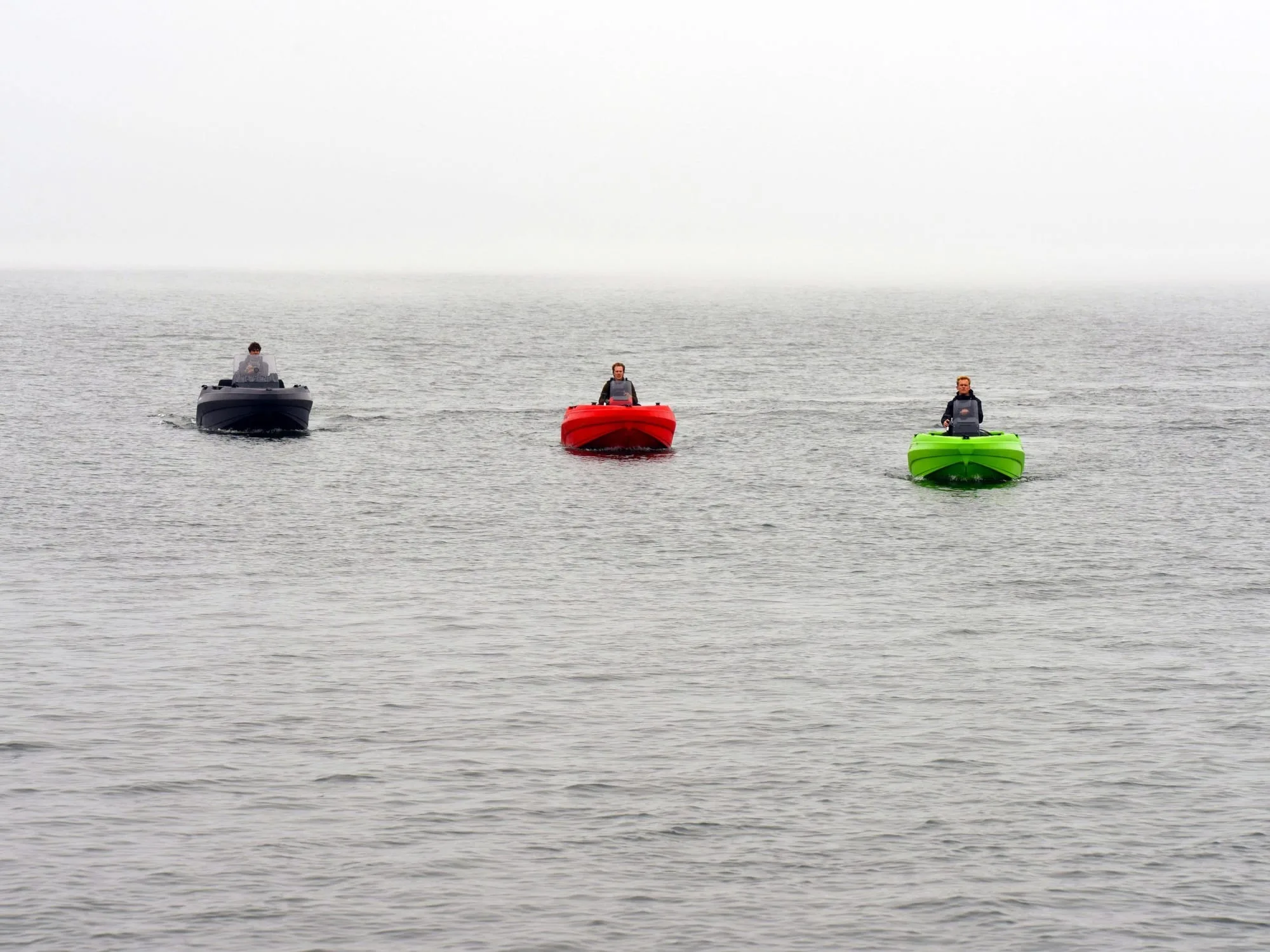 Three SeaStorm 12 boats in anthracite, red and green cruising side by side