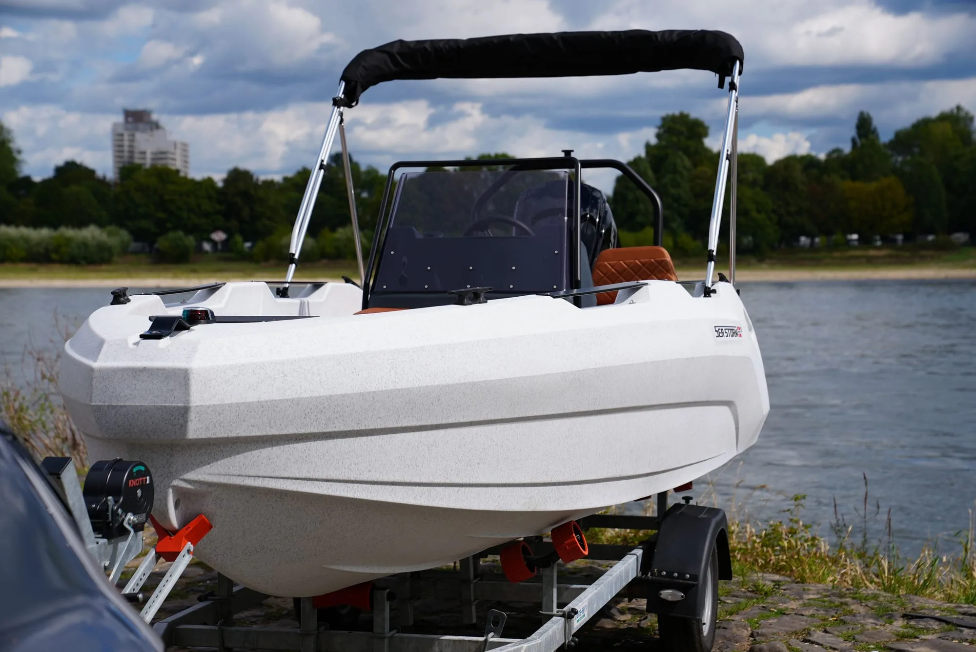 SeaStorm 17 head-on with helm station and bimini top